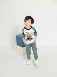 Dettaglio del set felpa rugby verde e pantaloni per bambino con stampa sportiva
