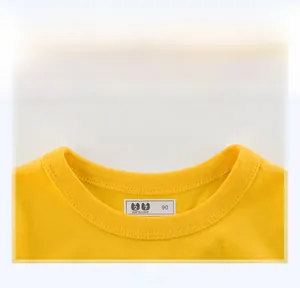 Gros plan du col rond côtelé et des doubles surpiqûres sur le t-shirt jaune pour enfant