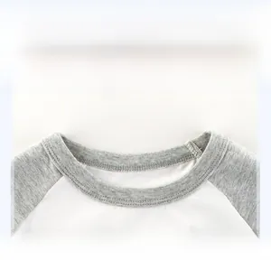 Detail of boys' raglan T-shirt showing round neck with grey ribbed collar and stitching