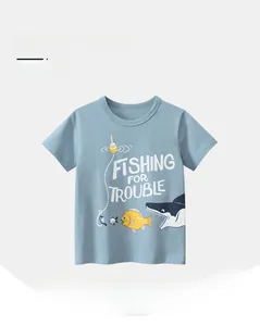 Detail of light blue cotton kids T-shirt with cartoon shark and Fishing For Trouble text