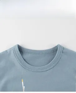 Detailed view of baby boy light blue cotton T-shirt neckline with fish float print