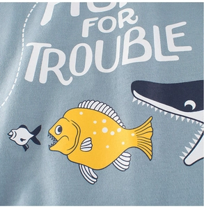 Detail of light blue cotton T-shirt featuring cartoon fish print and soft fabric texture