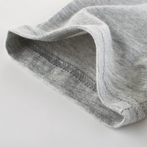 Close-up of boys' grey knit cotton T-shirt showing fine double-needle stitching on the cuff