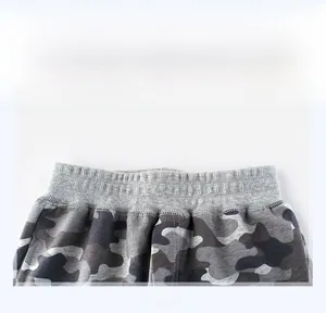 Detailed close-up of flexible elastic waistband on boys' grey camouflage joggers
