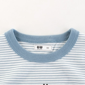 Gros plan d'un t-shirt rayé bleu et blanc pour enfants avec col rond en coton doux