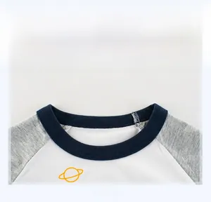 Dettaglio del girocollo e della stampa a pianeta giallo sulla t-shirt manica raglan