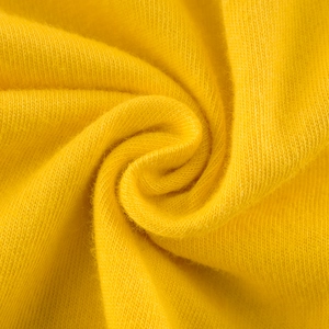 Detailed macro view of vibrant yellow knitted fabric for boys t-shirt with soft texture