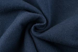 Macro shot of dark blue knit fabric texture showing high-density cotton weave detail