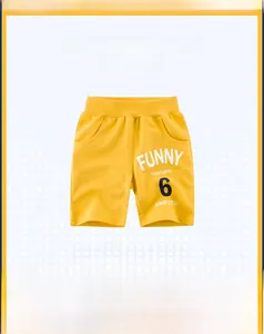 Detail of bright yellow kids knit shorts featuring bold FUNNY 6 graphic and ribbed waist