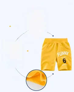 Detailed views of yellow cotton boys shorts showing elastic waistband and funny print