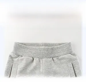 Dettaglio della fascia elastica a coste sui pantaloni sportivi grigi per bambini