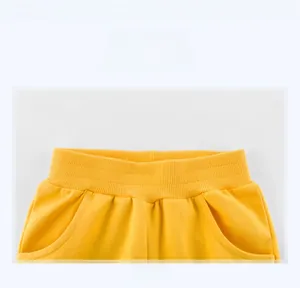 Detailed view of yellow kids knit shorts featuring ribbed elastic waistband and side pockets