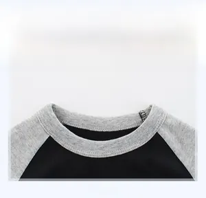 Detail shot of the grey ribbed crew neck and neat stitching on a black boys' T-shirt