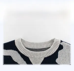 Detailed view of the gray ribbed crew neck and camouflage knit texture on kids' sweater