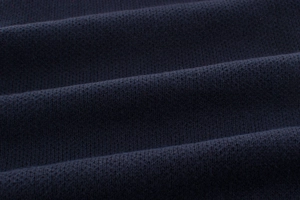 Detailed macro view of dark blue fine-knit sweater fabric texture and soft fiber finish