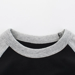 Close-up of boys' cotton raglan T-shirt showing round neck and grey ribbed collar detail