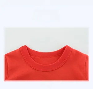 Macro detail of the ribbed crew neck and fine stitching on a red cotton kids' T-shirt