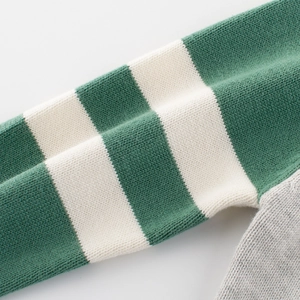 Close-up of kids striped knit sweater with green and beige sleeves and grey body part