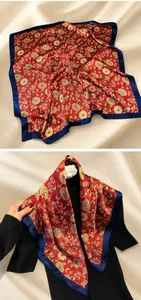 Detail of vintage floral silk scarf in red and gold with a satin finish and blue border