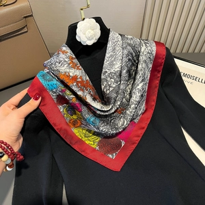 Red border silk square scarf with vintage floral prints displayed on a black sweater