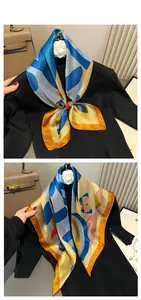 Detail of silk scarf with jumping horse print and geometric patterns on a black sweater