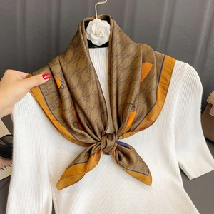 Silk-feel square scarf with vintage pattern tied on a white knit sweater neck