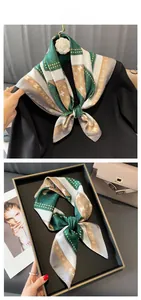 Detail of silk-like scarf with bear print and letter monogram in green and beige