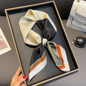 Eleganter 70cm Seidenschal mit geometrischem Farbmuster auf einem Tablett mit Accessoires