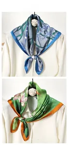 Detailed view of floral silk-like scarves in blue and green with elegant flower patterns