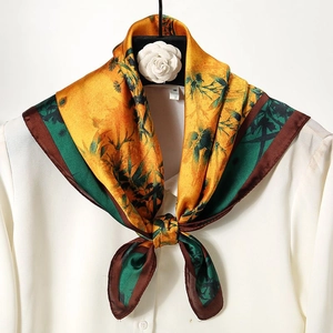 Detail of vintage bamboo floral print silk scarf tied as a bow on white shirt collar