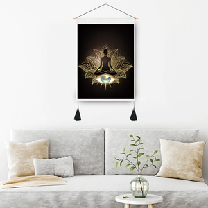 Golden lotus meditation scroll painting with tassels on a gray wall above the sofa