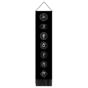 Detailed view of black vertical chakra tapestry with white symbols and elegant fringe