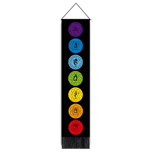 Close-up of bohemian seven chakra wall tapestry with black tassels and wood hanging rod