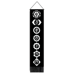 Detailed view of black seven chakra wall hanging with white symbols and tassel trim