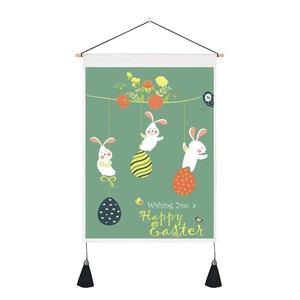 Detail of Easter wall tapestry featuring white rabbits and tassels on a green background