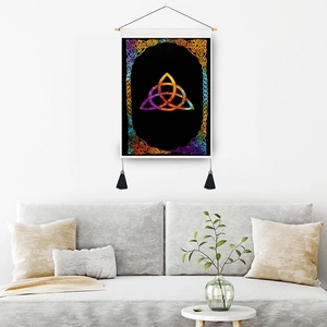 Vintage Celtic Trinity Knot wall hanging with rainbow colors and black tassels on white wall