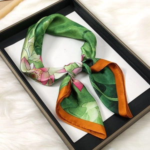 Detail of green floral silk scarf with lotus print elegantly placed in a gift tray