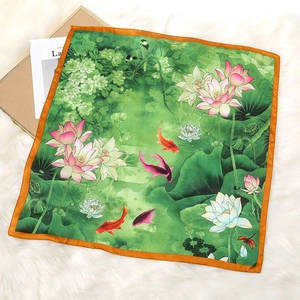 Detailed view of emerald green silk square scarf with lotus and koi fish patterns