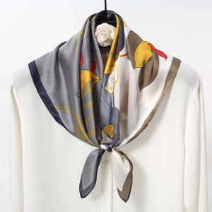 Elegant 70cm silk satin square scarf with yellow floral print tied on a white shirt neck
