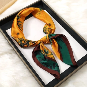 Detail of silk square scarf with yellow floral pattern and brown rolled hem edges