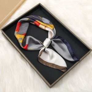 Elegant 70cm satin silk scarf with abstract artistic print on a black wooden tray