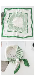 Détail de l'imprimé lettres vertes et rayures géométriques sur foulard en soie