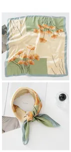 Detailed view of satin silk scarf featuring ginkgo leaf patterns and geometric blocks