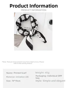 Détail de l'imprimé fleur de camélia et des pois noirs sur le foulard en imitation soie