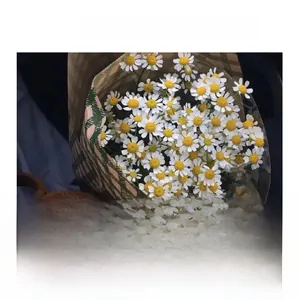 Détail d'un foulard en soie à carreaux classiques enveloppant un bouquet de marguerites