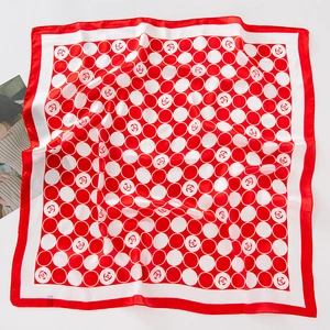 Détail d'un foulard carré à pois rouges et blancs avec de petits motifs de roses