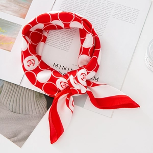 Foulard en soie rouge à pois floraux blancs présenté sur un magazine minimaliste chic