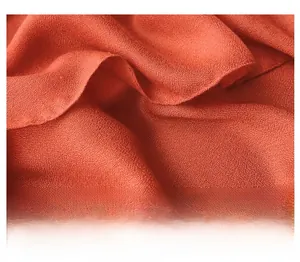 Gros plan sur l'écharpe en coton et lin rouge-orangé avec texture de tissu fin tissé