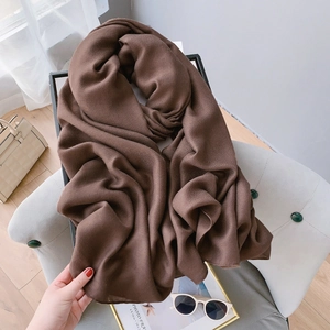 Texture détaillée d'une écharpe épaisse marron café en coton lin sur une chaise douce