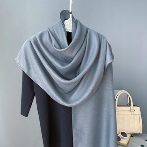 Écharpe élégante en coton et lin gris-bleu drapée sur un vêtement noir, style minimaliste